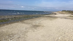 A sandy beach with a clear view of the ocean and distant wind turbines. - 4 Person Holiday Home in Vinderup (Vinderup)