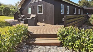 A wooden cabin with a deck, outdoor seating, and a wooden fence. - 4 Person Holiday Home in Vinderup (Vinderup)