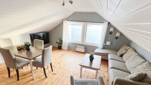 Un loft acogedor con comedor, sofá y televisor.