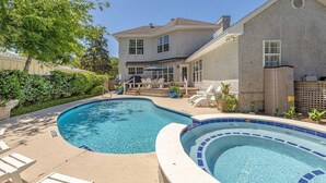 A swimming pool with two distinct sections, a patio area with lounge chairs, and a two-story house with a covered patio. - 4324 10th Street East Beach (Saint Simons Island)