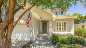A two-story house with a front porch, a mailbox, and an American flag. - 4324 10th Street East Beach (Saint Simons Island)
