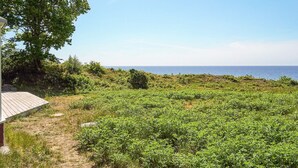 A coastal landscape with a wooden deck and a view of the sea. - 4 Star Holiday Home in Aakirkeby (Akirkeby)