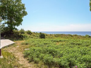 A coastal landscape with a wooden deck and a view of the sea. - 4 Star Holiday Home in Aakirkeby (Akirkeby)