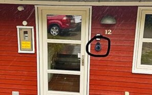 A red building with a door, a mailbox, and a number '12' on the wall. - 4 Star Holiday Home in Aakirkeby (Akirkeby)