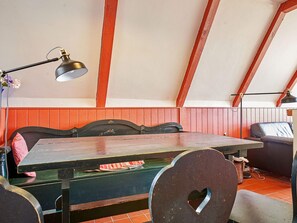 A dining area with a wooden table and chairs, a bench, and a lamp. - 4 Star Holiday Home in Aakirkeby (Akirkeby)