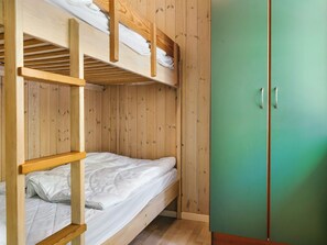 A bunk bed with a green wardrobe and a wooden floor. - 4 Star Holiday Home in Aakirkeby (Akirkeby)