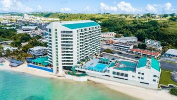 A high-rise hotel with multiple floors, a rooftop pool, and a beachside location.