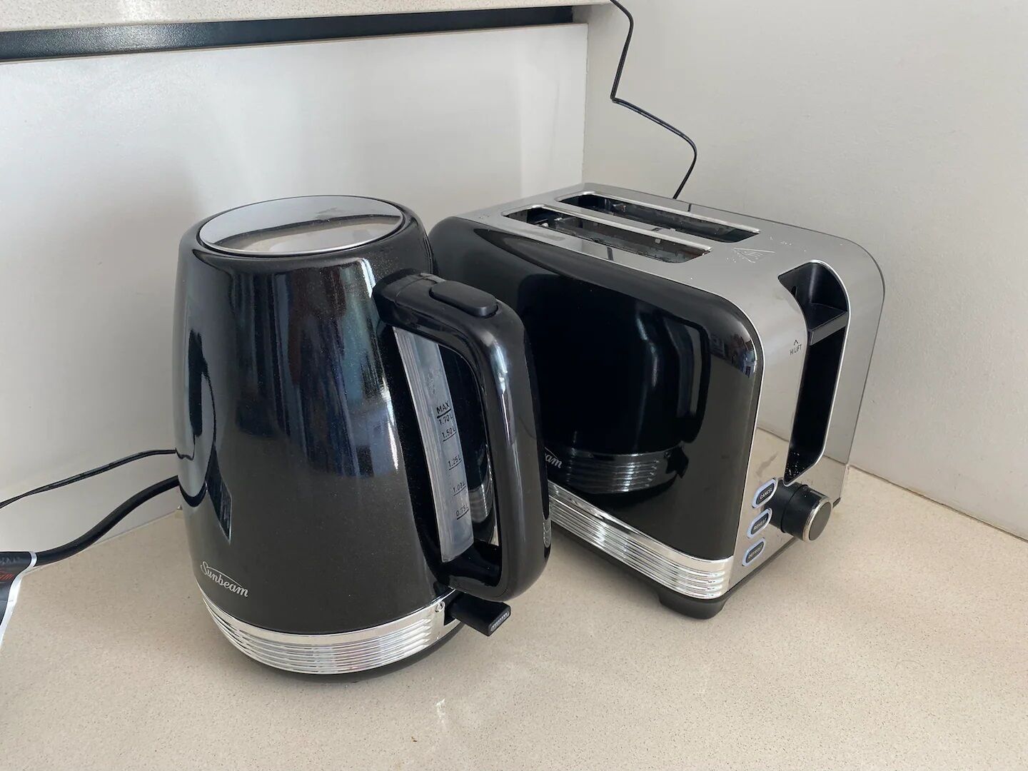 Ein Sunbeam Wasserkocher und Toaster stehen auf einer Arbeitsplatte.