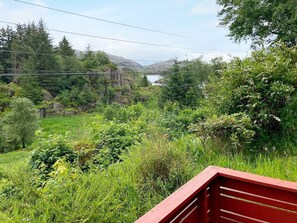 A natural landscape with a lake, greenery, and a red structure. - 4 Person Holiday Home in Hardbakke (Solund)