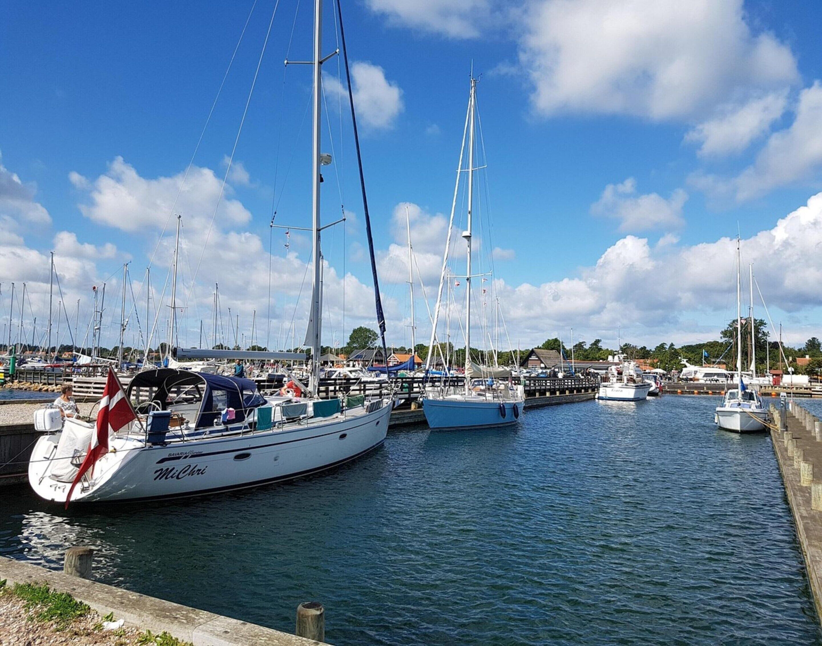 Un puerto deportivo con varios veleros amarrados al muelle.