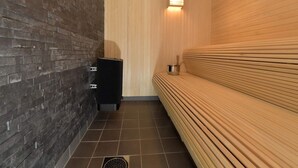 A sauna room with a brick wall, a wooden bench, and a small heater. - 4 Star Holiday Home in Idre (Idre)