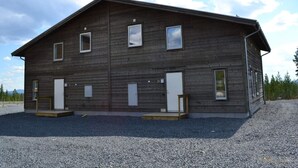 A two-story wooden building with multiple windows and a gravel driveway. - 4 Star Holiday Home in Idre (Idre)