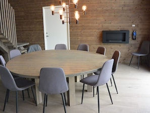 A conference room with a large round table, grey upholstered chairs, a modern light fixture, and a flat-screen TV mounted on the wall. - 4 Star Holiday Home in Idre (Idre)