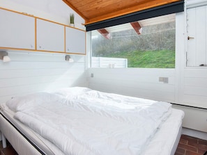 Quarto com cama, janela e vista para o exterior.
