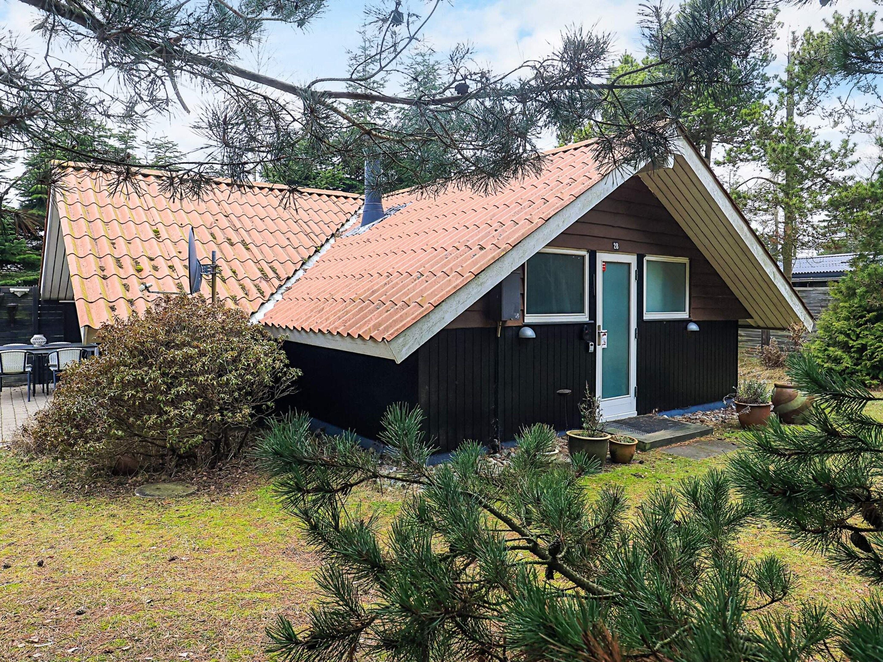 En hyggelig hytte med skrå vægge, en dør og et vindue.
