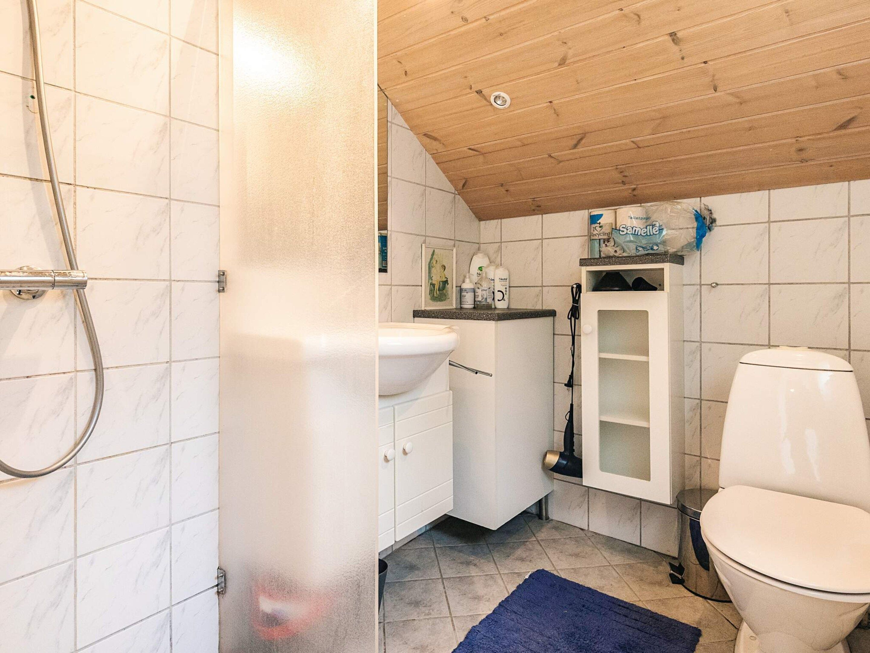 Kylpyhuone, jossa on suihku, pesuallas, wc ja kaappi.