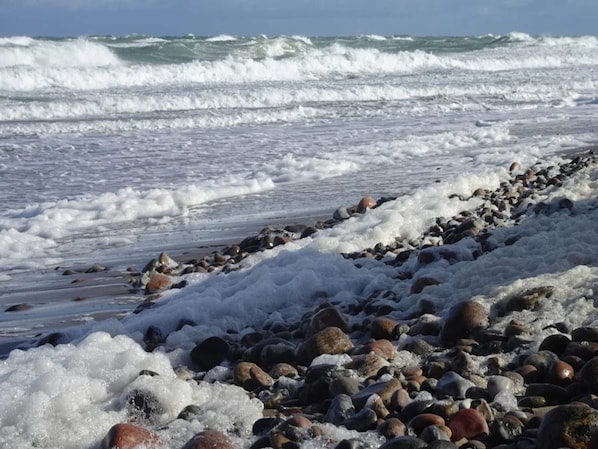 A rocky shoreline with waves crashing onto the beach.