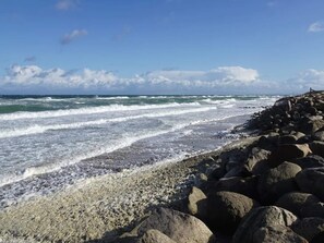 Una playa rocosa con olas rompiendo en la orilla.