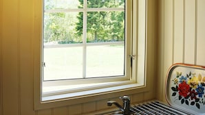 Eine Küche mit Fenster, einer Edelstahl-Spüle und einem Wäscheständer.