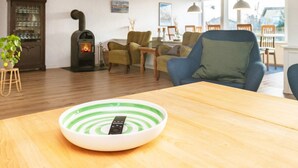 A cozy living room with a fireplace, comfortable seating, and a bowl with a remote control. - 8 Person Holiday Home in Skagen (Skagen)
