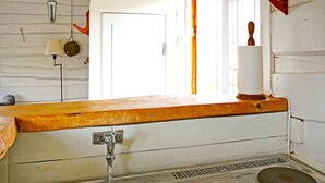 Una cocina con un lavamanos, una encimera de madera y una ventana con vistas.