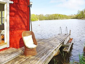 Una banchina di legno che si estende in acqua, con una sedia in vimini.