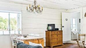 Una habitación acogedora con una mesa de comedor de madera, un sofá, un aparador de madera y una araña.