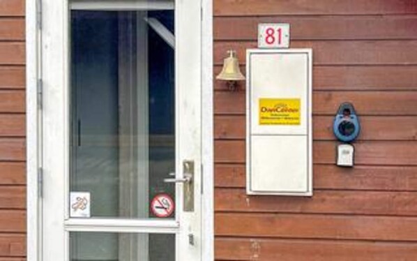 A wooden exterior wall with a door, a mailbox, and a bell. - 7 Person Holiday Home in Toftlund-by Traum (Toftlund)