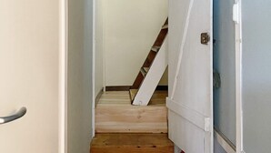 A narrow hallway with a wooden staircase leading to a door with a metal handle. - 6 Person Holiday Home in Lidkoping (Lidköping)