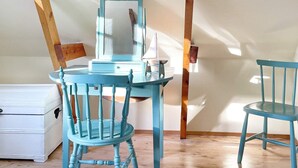 A room with a blue-painted desk, a chair, a mirror, and a dresser. - 6 Person Holiday Home in Lidkoping (Lidköping)