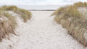 A sandy beach path with dunes on either side leading to the sea. - 4 Person Holiday Home in Lottorp (Byxelkrok)