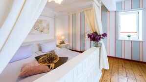 A bedroom with a bed, bedside table, lamp, and a window with curtains. - Ackerbürgerhof Ballstraße 18 (Quedlinburg)