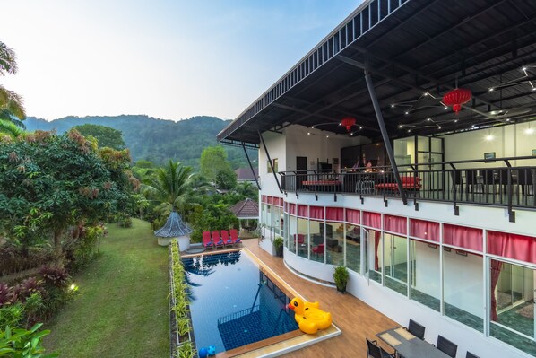 Un hôtel moderne doté d’une piscine, d’un espace extérieur am énagé et offrant une vue sur la verdure environnante.