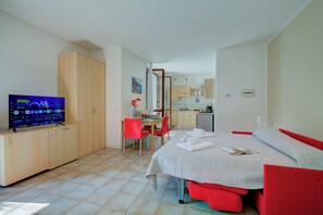 Une chambre à coucher avec un lit, une télévision, un bureau et une chaise.