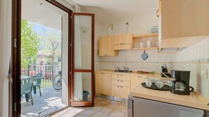 Eine Küche mit Holzausstattung, einer Kaffeemaschine und einem Essbereich mit Stühlen und einem Tisch.
