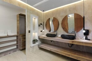 Une salle de bain moderne avec un meuble-lavabo en bois, deux grands miroirs et un lavabo noir.