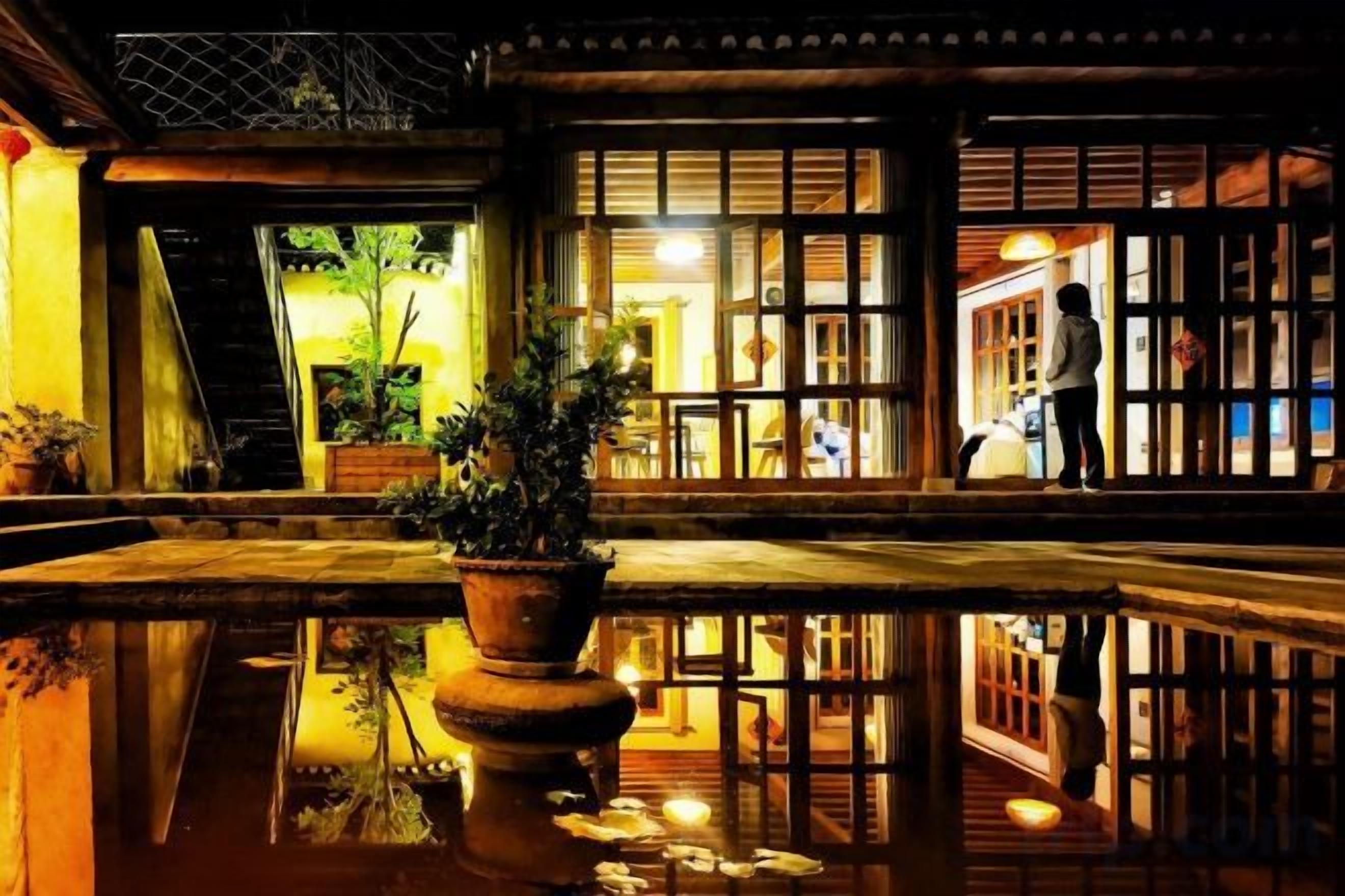 Ein traditionelles japanisches Gebäude mit einem spiegelnden Wasserspiel im Vordergrund.