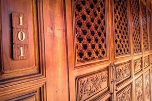 Una puerta de madera con paneles tallados y el número '101' a la vista.