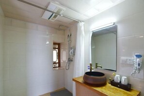 A bathroom with a shower, a sink with a round basin, a mirror, and a window. - Shaxi Serenity Residence (Jianchuan)