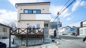 A modern two-story building with a flat roof and a wooden entrance gate. - SUMIYOSHI HOUSE ROOMB (Otaru)