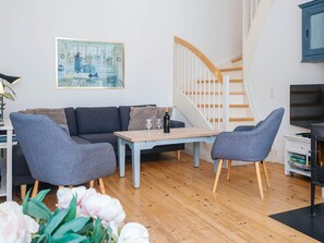 A modern living room with a sofa, two armchairs, a coffee table, and a painting on the wall. - 4 Star Holiday Home in Ringkobing (Ringkobing)