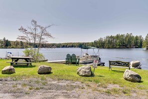Un espace de pique-nique au bord du lac, équipé d’un banc, d’une table de pique-nique et d’un bateau amarré à proximité.
