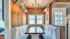 A dining area with a long table and benches, wooden ceiling, and large windows. - Forestport Home w/ Access to Otter Lake (Forestport)