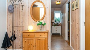 A wooden interior with a mirror, a light fixture, and a coat rack. - 7 Person Holiday Home in Hvide Sande-by Traum (Hvide Sande)