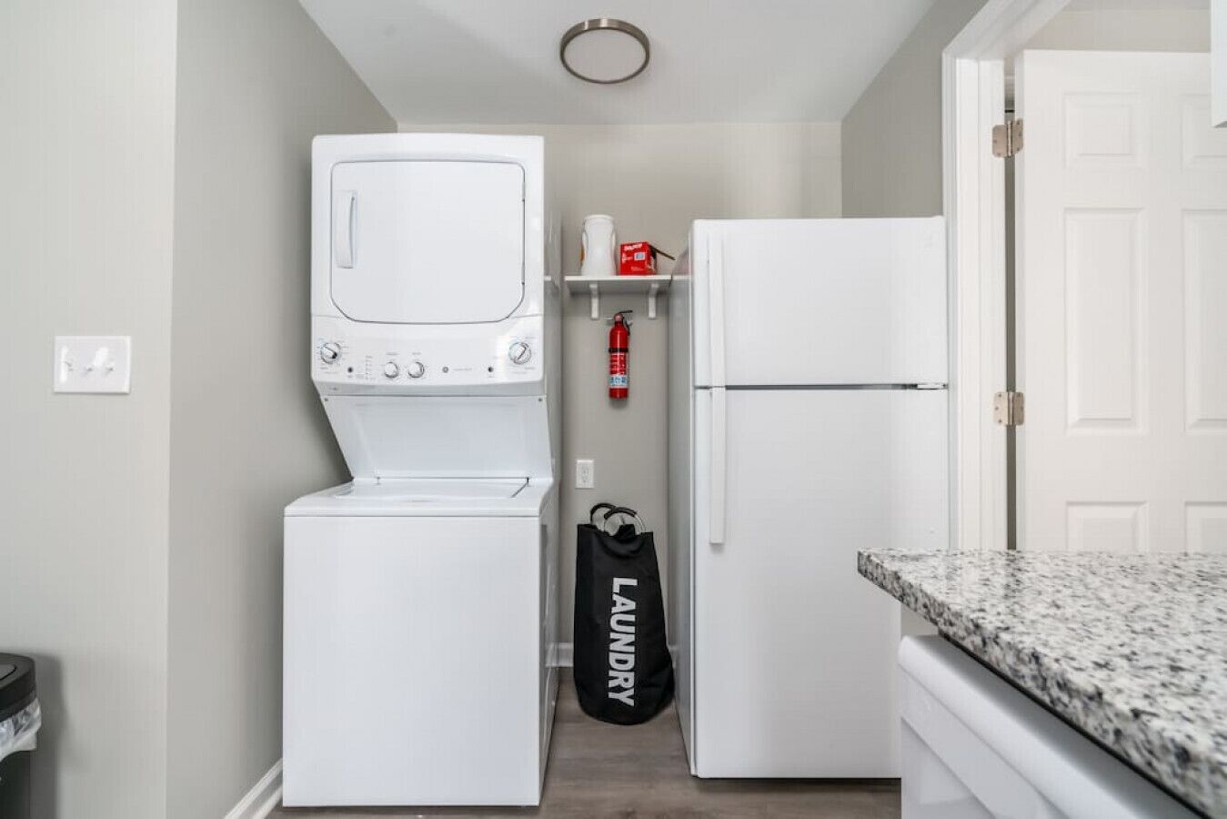 A compact laundry room with a washer, dryer, and refrigerator.