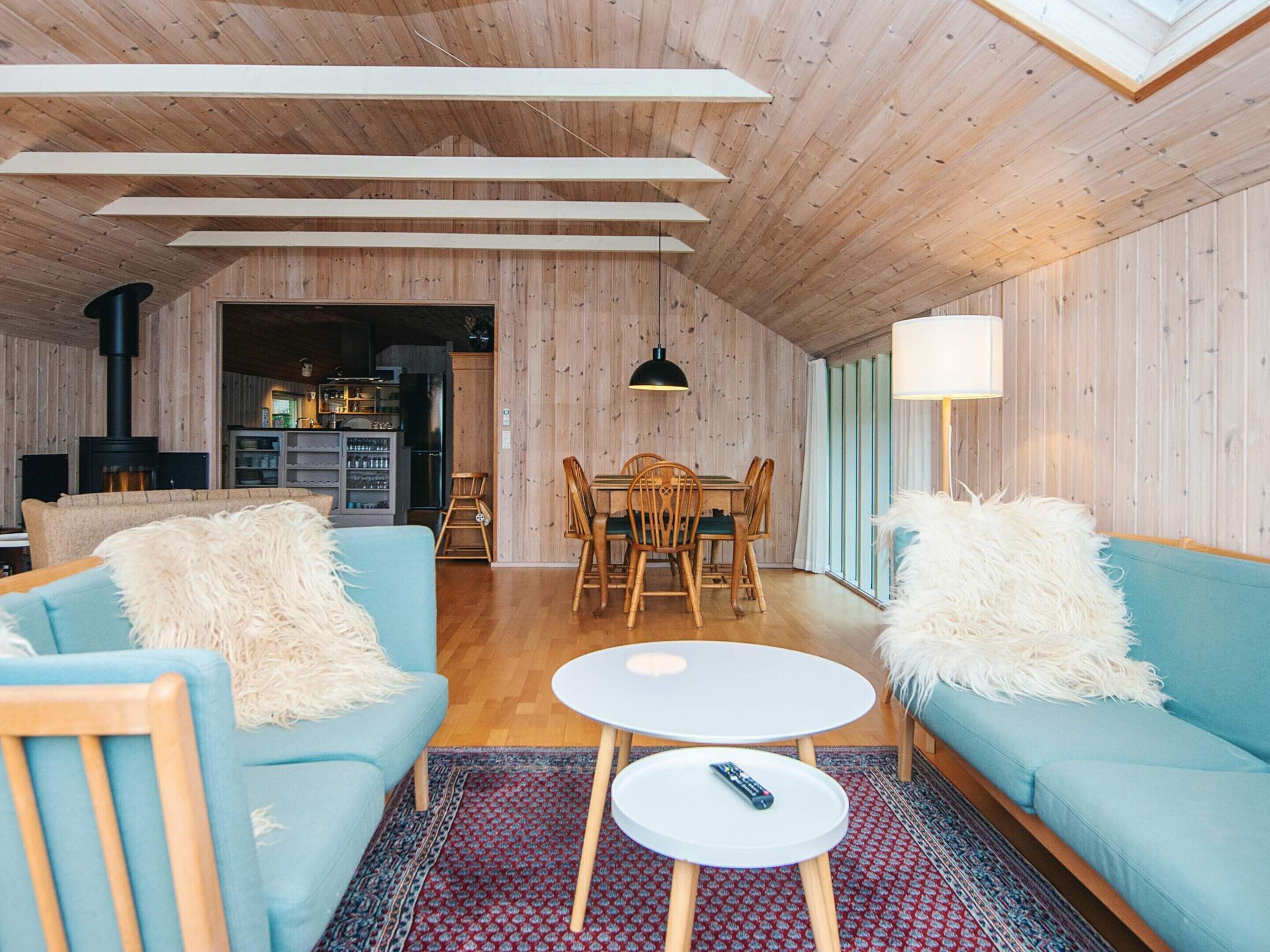 A cozy living room with a sofa, a coffee table, and a dining area with chairs and a table.
