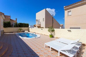 A residential property with a swimming pool, lounge chairs, and a tiled patio. - CH Villa Rio Mundo Rojales (Rojales)