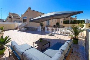 A rooftop patio with outdoor seating, a covered area, and a pool.