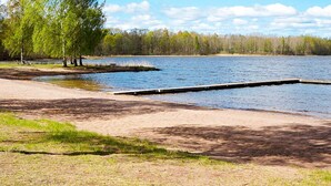 A lakeside park with a dock, grassy areas, and trees. - 5 Star Holiday Home in Odensvi (Gamleby)