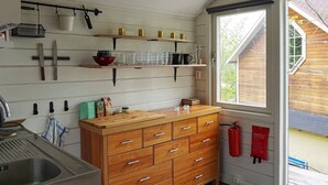 A kitchen with wooden cabinets, a sink, and a window with a view of the outside. - 2 Person Holiday Home in Haninge-by Traum (Tyreso)